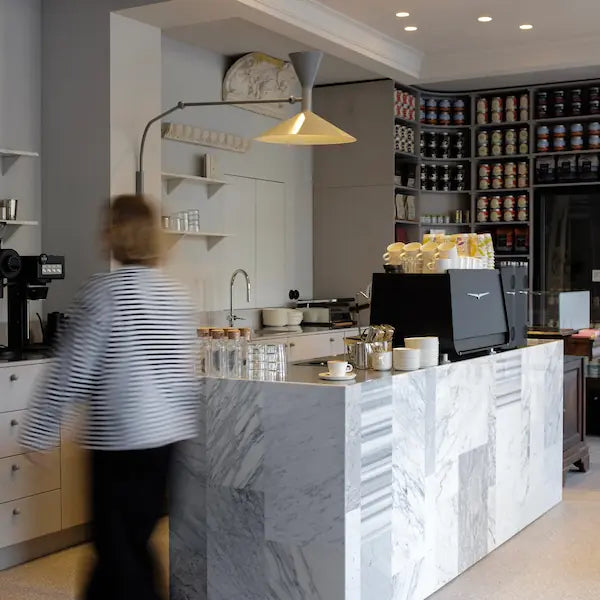 Modern coffee shop interior with a counter and shelves stocked with coffee beans.