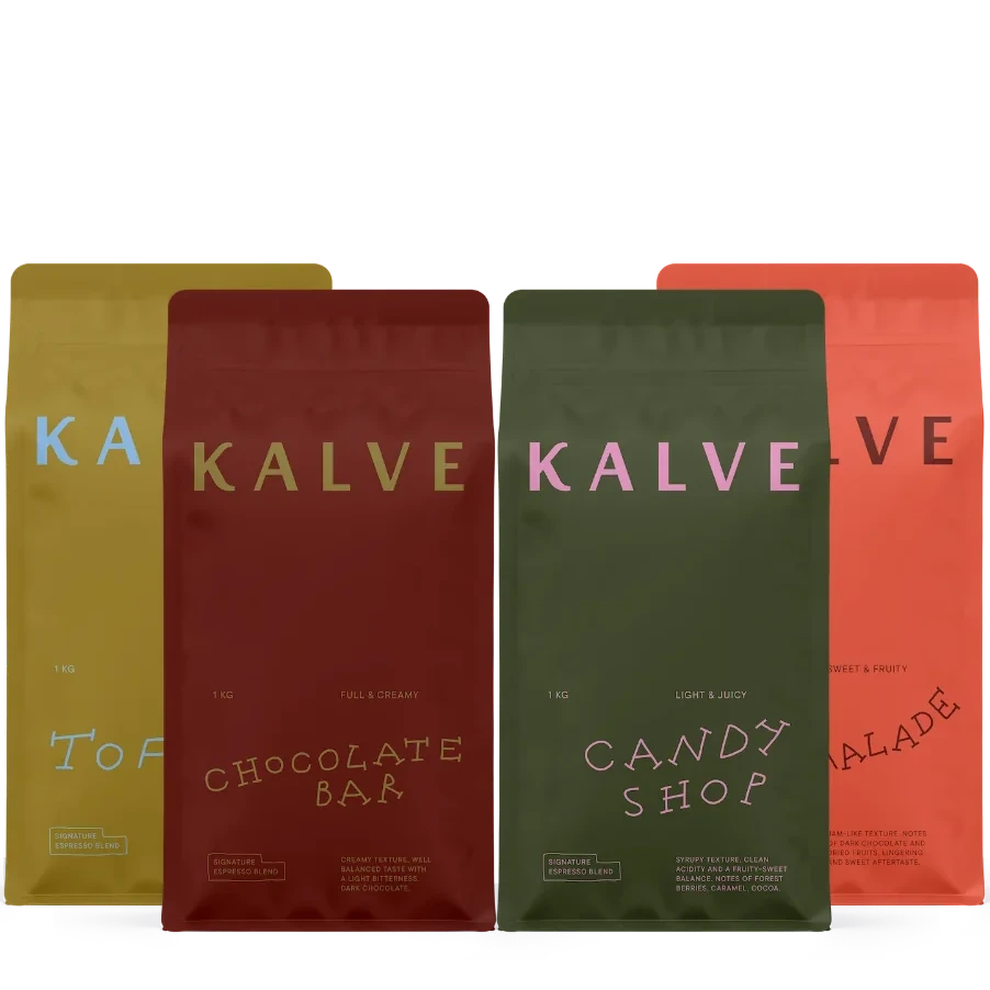 Four colorful 1kg bags of Kalve coffee with different flavors on a white background