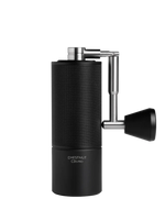 Black coffee grinder with metallic accents on a white background