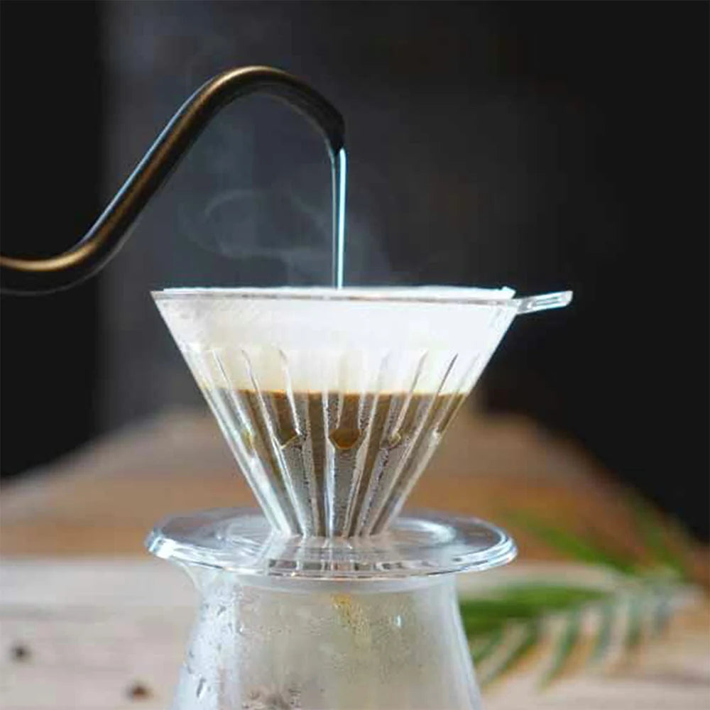 Dripper on coffee server with water pouring on the coffee grounds