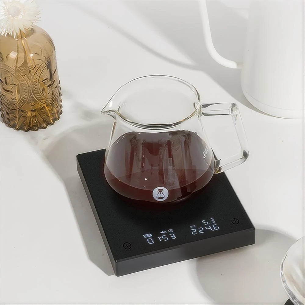 Glass coffee carafe on a digital scale with a white background