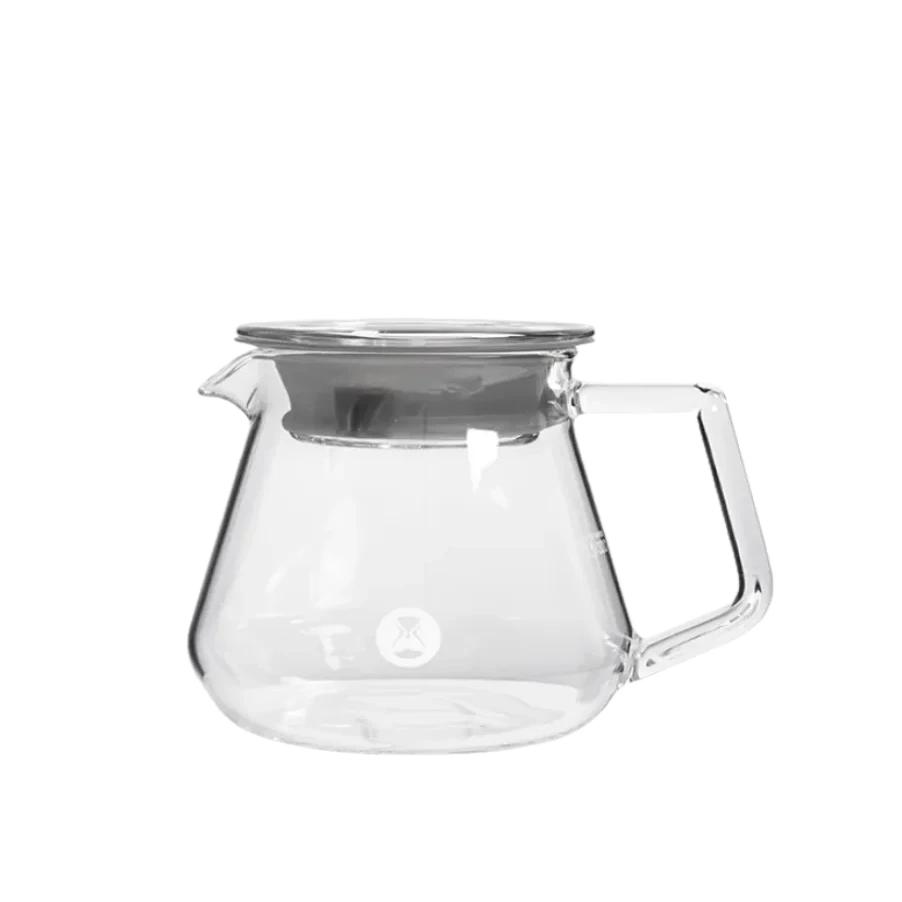 Clear glass server with a silver lid on a white background