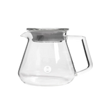 Clear glass server with metal lid on a white background